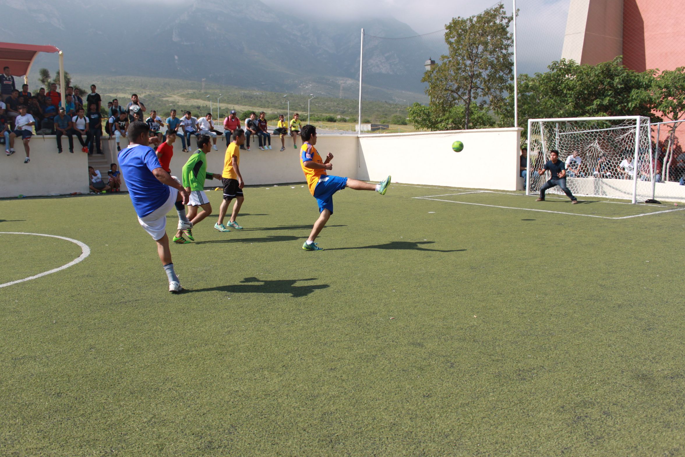 La imagen muestra a  algunos estudiantes jugando futbol.